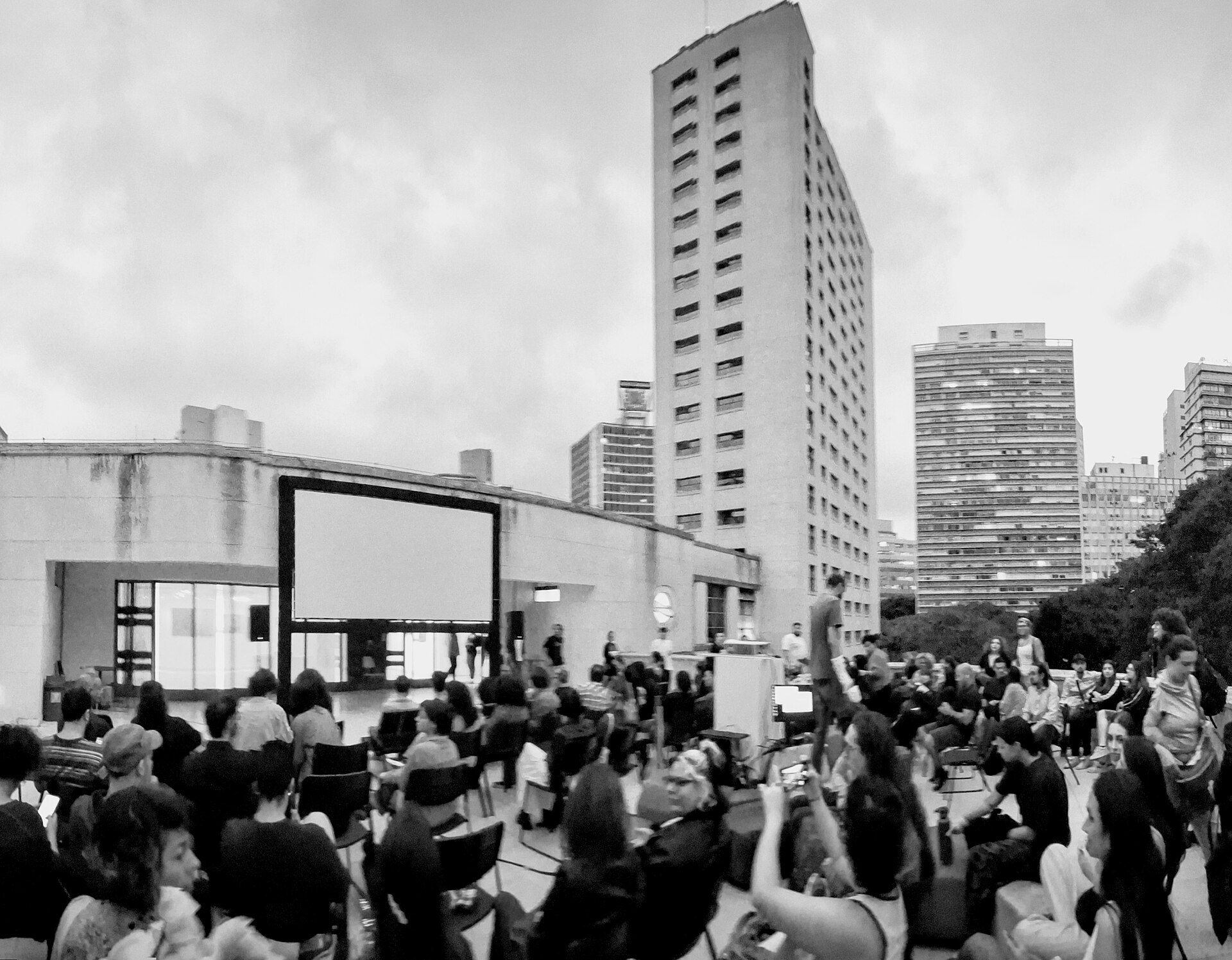 Séance en plein air, écran blanc et public de dos